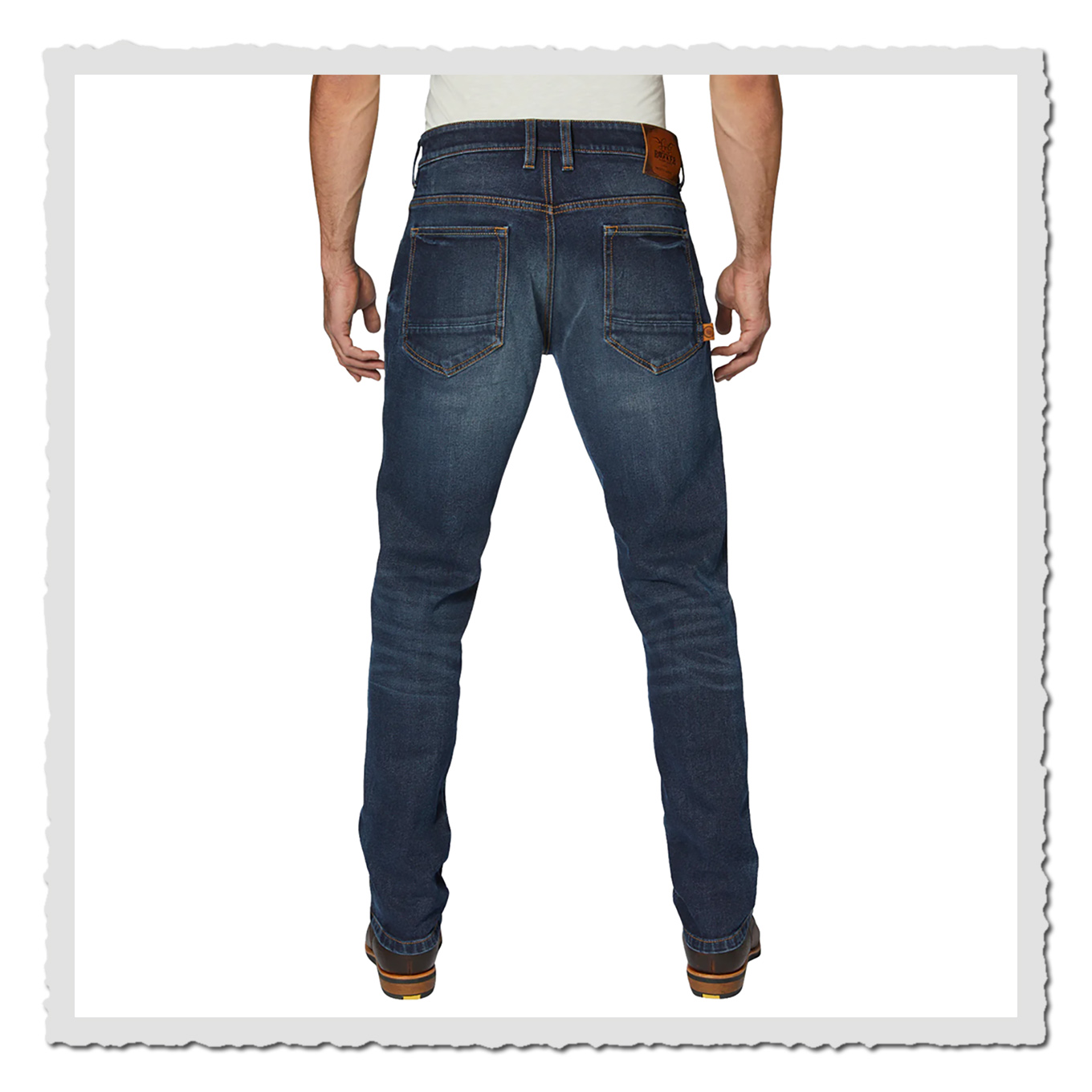 Mann trägt dunkelblaue Jeans in Rückansicht mit zwei Gesäßtaschen und braunem Etikett am Bund.